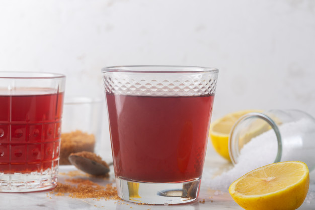 Домашний изотонический энергетический напиток и ингредиенты. стакан с красной жидкостью, натуральный спортивный напиток | Премиум Фото